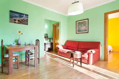 a living room with a red couch and a table at Sitges Malvasia · Paz en el Corazón de Sitges in Sitges