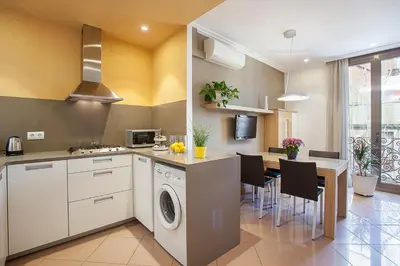 a kitchen with a washing machine and a dining room at BCNGOTIC 42 in Barcelona