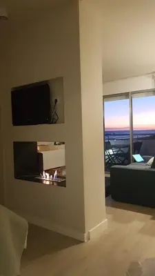 a living room with a fireplace with a tv above it at Gava Ocean View in Gavà