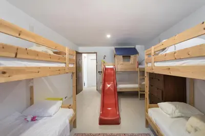 a dorm room with two bunk beds and a red slide at Villa Costa Barcelona in Arenys de Munt