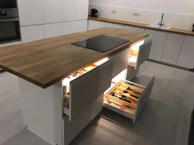 a kitchen island with an open drawer with knives at Villa Costa Barcelona in Arenys de Munt