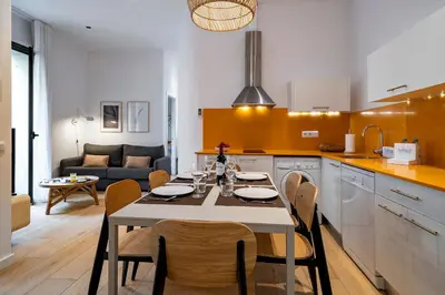 a kitchen and living room with a table and chairs at Verdi Habitat Apartments in Barcelona