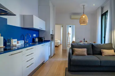 a kitchen and living room with a couch in a room at Verdi Habitat Apartments in Barcelona