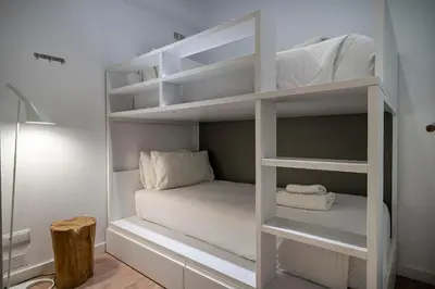 a room with white bunk beds in a room at Verdi Habitat Apartments in Barcelona