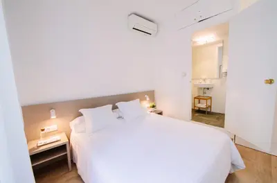 a white bedroom with a large white bed at Hostalet de Barcelona in Barcelona