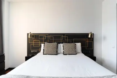 a bedroom with a white bed with a black headboard at TSA Sepulveda in Barcelona