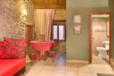 a living room with a table and a bathroom at Sant Marçal del Montseny in Montseny