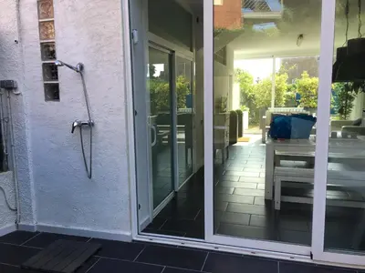 an open door to a patio with an umbrella at Beach House in Castelldefels