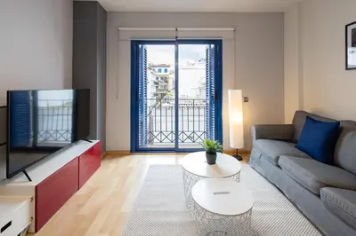 a living room with a couch and a tv at Lucas House Apartments by Sitges Group in Sitges