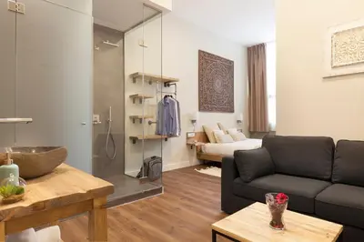 a living room with a couch and a glass shower at Hotel Radha in Hospitalet de Llobregat