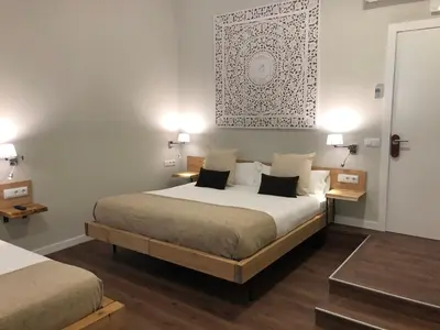 a bedroom with a large bed and two tables at Hotel Radha in Hospitalet de Llobregat