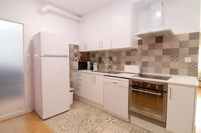a living room with a table and a kitchen at Apartaments IXA in Manresa