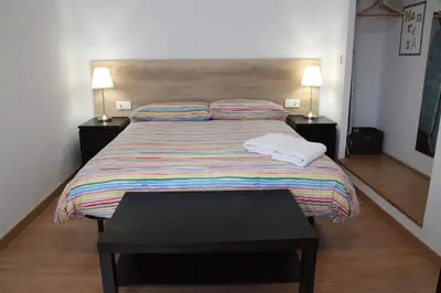 a living room with a chair and a television on a wall at Apartaments IXA in Manresa