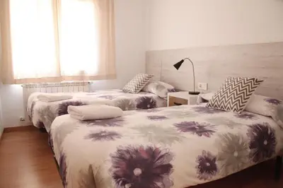 a bedroom with two beds and a lamp at Apartaments IXA in Manresa