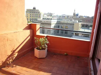 a balcony with a potted plant and a view of a city at Apartaments Sant Jordi Girona 97 in Barcelona