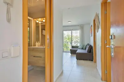 a hallway leading to a living room with a couch at Apartamentos Velor in Castelldefels