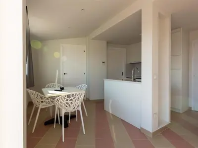 a kitchen and dining room with a table and chairs at Apartamentos Sunway Atlanta in Sitges