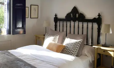 a bedroom with a bed with white sheets and pillows at Can Calixto in Aiguafreda
