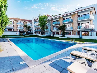 a swimming pool in front of a building at Apartamentos Sunway Apollo in Sitges