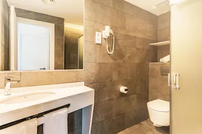 a bathroom with a sink and a toilet and a mirror at Apartamentos Sunway Apollo in Sitges