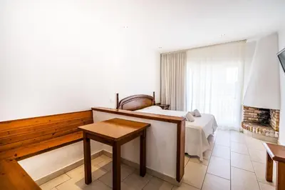 a bedroom with a bed and a table in a room at Apartamentos Sunway San Jorge in Sitges