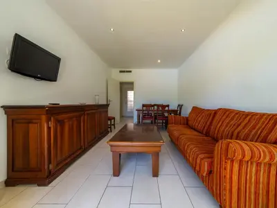 a living room with a couch and a flat screen tv at Apartamentos Sunway San Jorge in Sitges