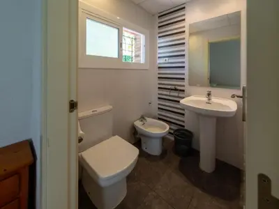 a white bathroom with a toilet and a sink at Apartamentos Sunway San Jorge in Sitges