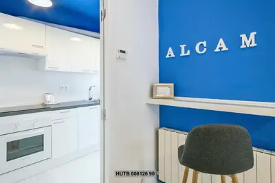 a kitchen with a chair and a blue wall at Alcam Rogent in Barcelona