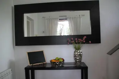 a mirror on a wall with a vase of fruit on a table at Villa Rosa Sitges in Can Trabal
