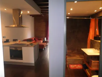 a room with a kitchen and a living room at Bacrou apartment, design loft near the sea in Barcelona