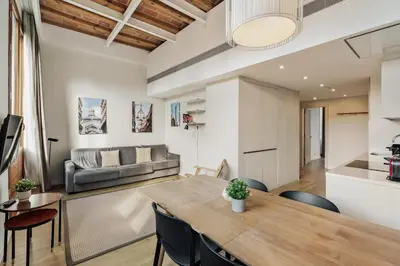a dining room and living room with a table and chairs at Ola Living Boqueria in Barcelona