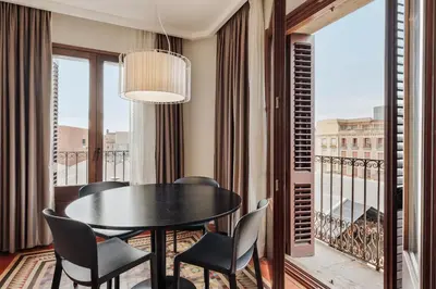 a dining room with a table and chairs on a balcony at Ola Living Boqueria in Barcelona