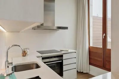 a white kitchen with a sink and a stove at Ola Living Boqueria in Barcelona