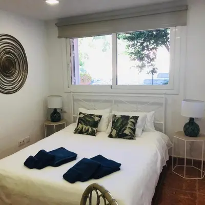 a bedroom with a bed with two blue pillows on it at Casa Mallarenga Rooms in Olivella