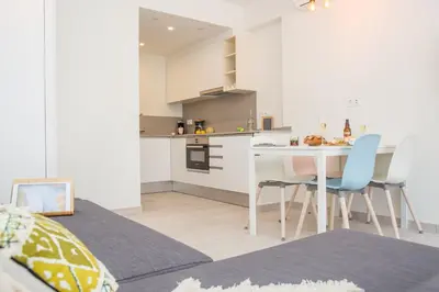 a kitchen and dining room with a table and chairs at Rambla de Marisol Apartments in Castelldefels