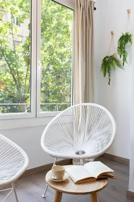 a room with a white chair and a window at KeyFamily Cozy Home in Barcelona
