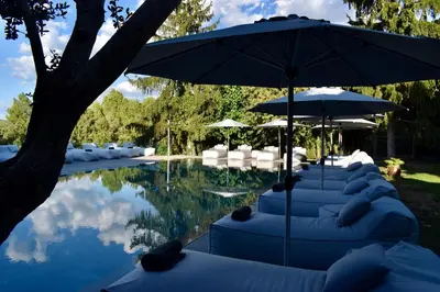 a pool with lounge chairs and umbrellas next to a pool at Boutique hotel Urbisol in Calders