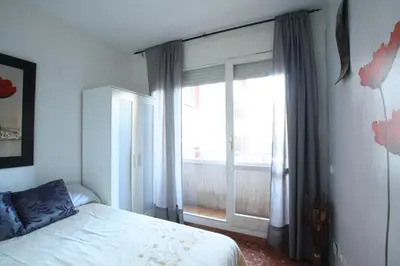 a bedroom with a bed and a large window at Good-Apartments Barcelona in Barcelona