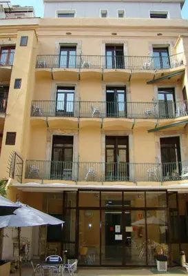 an apartment building with tables and chairs in front of it at La Terrassa in Barcelona