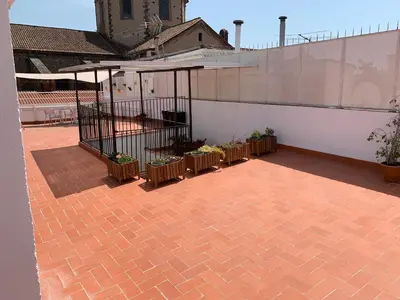a patio with tables and plants on a building at La Terrassa in Barcelona