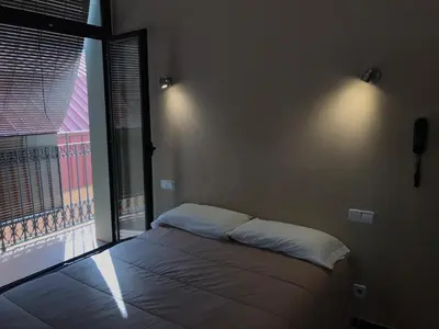 a bedroom with a bed and a large window at Hostal Radio Barcelona in Barcelona