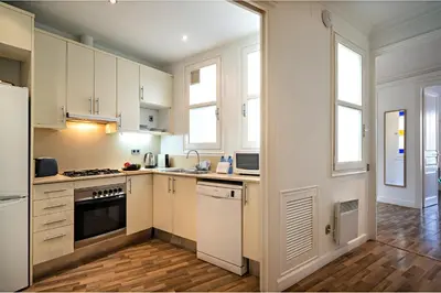 a kitchen with white cabinets and white appliances at Habitat Apartments Eixample Balconies. in Barcelona