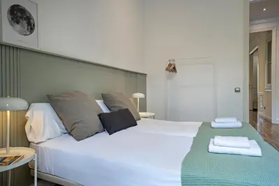 a bedroom with a large white bed with towels on it at Habitat Apartments Eixample Balconies. in Barcelona