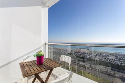 a table and chairs on a balcony with a view of the ocean at 1410 - Mediterranean Forum Apartment in Barcelona