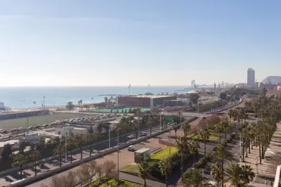 a view of a street with palm trees and the ocean at 1410 - Mediterranean Forum Apartment in Barcelona