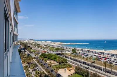 a view of a beach and a road with cars at 1410 - Mediterranean Forum Apartment in Barcelona