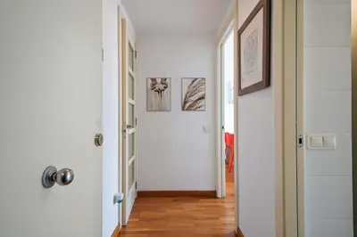 a hallway with white walls and wooden floors at 1213 - Ciutadella Nice Apartment in Barcelona