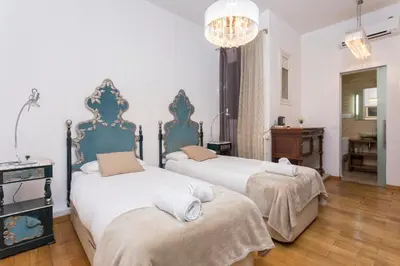 a bedroom with two beds and a chandelier at 1229 - AWESOME CITY CENTER APARTMENT WITH TERRACE in Barcelona