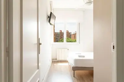 a white room with a bed and a window at Cozy Apartment near Fira Gran Via with AC in Hospitalet de Llobregat