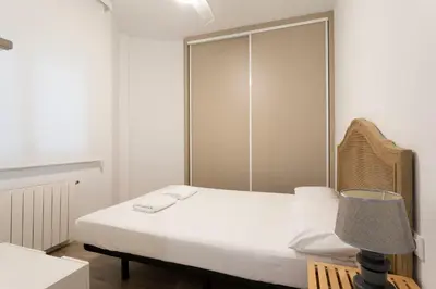 a bedroom with a white bed and a lamp at Cozy Apartment near Fira Gran Via with AC in Hospitalet de Llobregat